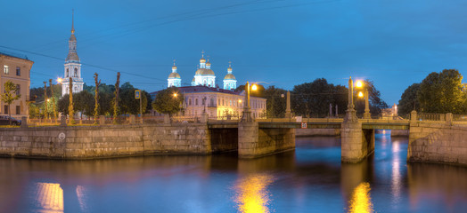 Night view on illuminated Griboedov Canal, Pikalov Bridge and St. Nicholas Naval Cathedral, St. Petersburg, Russia.