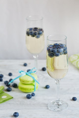 Glasses of champagne with blueberries and green macaroons