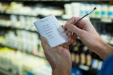 Man ticking on shopping checklist