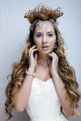 beauty young snow queen with hair crown on her head, complicate hairstyle, winter concept