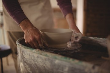 Fototapeta na wymiar Male potter making bowl