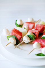 Watermelon kebab with spicy sauce, basil and mozzarella cheese