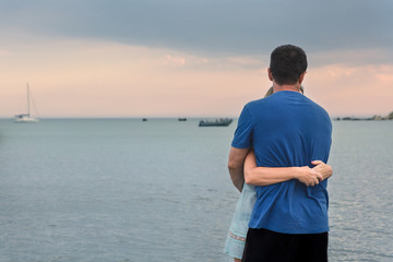 Man and woman embracing on the beach in the evening