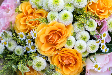 Bouquet of flowers; orange roses, chamomile, eustoma.