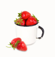 Fresh ripe red strawberries in enamel mug over white background, copy space