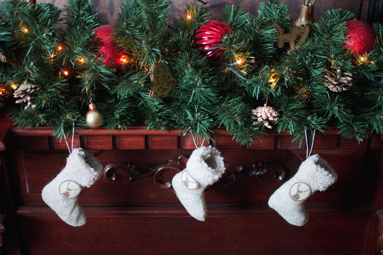 Three christmas socks, garland and tree branch