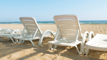 White chairs are placed on the beach for people to relax or sunbath. Beaches make a wonderful vacation spot. One of the most beautiful sceneries.