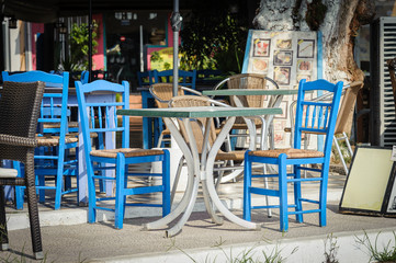 Blue wooden chairs and table at traditional Greek tavern