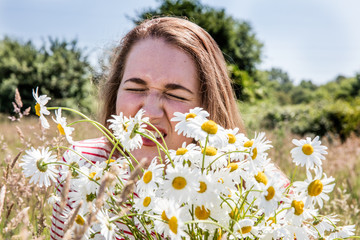 frowning girl with pollen allergies or hay fever sneezing outdoors - obrazy, fototapety, plakaty