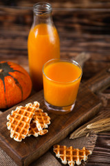 Bottle and Glass of fresh pumpkin juice with wafer and pumpkin o