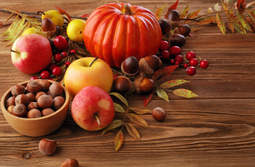 autumn apples, pumpkin, nuts and flowers on wooden table