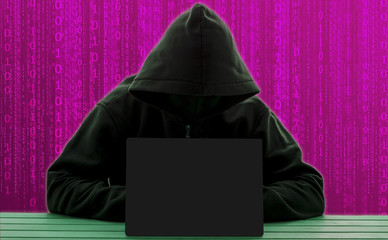 Computer hacker silhouette of hooded man with binary data .Computer networks the concept of...