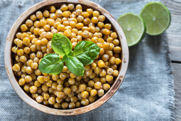 Bowl of roasted chickpeas on the wooden background