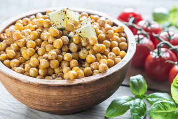 Bowl of roasted chickpeas on the wooden background