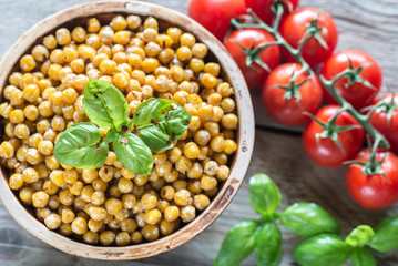 Bowl of roasted chickpeas on the wooden background