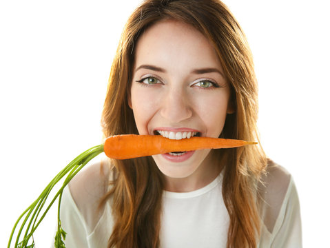 Beautiful girl eating carrot, isolated on white