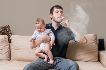 Bad father is smoking and holding baby. A lot of smoke around.