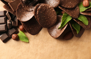 Chocolate chips and mint leaves on parchment background