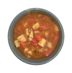 Bowl of Manhattan style clam chowder top view on a white background.