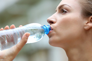 Beautiful girl drinking water on street