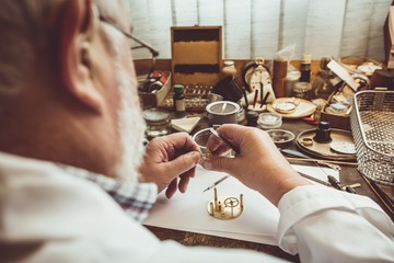Rear view of horologist repairing a watch