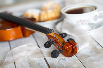 Coffee with cupcakes and violin on the wooden table 
