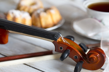 Coffee with cupcakes and violin on the wooden table 