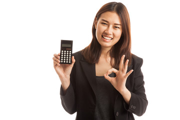 Asian business woman show OK with calculator.