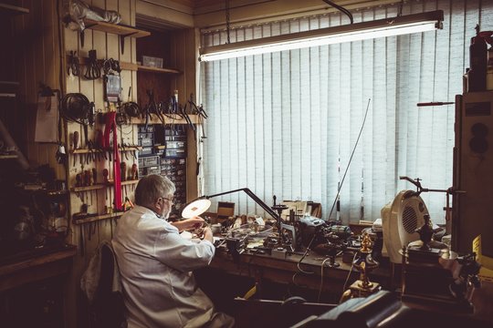 Rear view of horologist repairing a watch