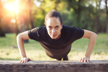 Training outdoors. Beautiful sport woman doing pushups.