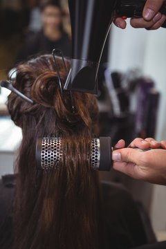 Woman getting her hair dried with hair dryer