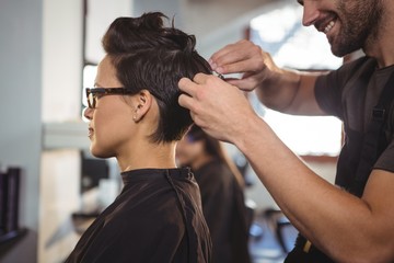 Male hairdresser styling customers hair