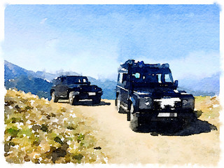 Digital watercolor painting of two 4x4 vehicles on top of a mountain. With space for text. © anitalvdb