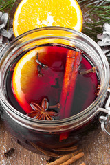 Christmas drink with orange fruit, anise, cinnamon and cloves on wooden table