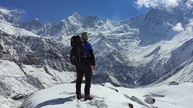 Hiker standing in Annapurna mountain valley. Snow peak in background. Himalayas Nepal travel HD video.
