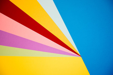 Color papers geometry flat composition background with yellow orange red violet and blue tones