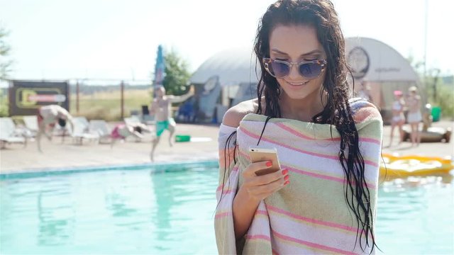 Portrait of beautiful girl taking a mobile phone at the swimming pool. 20s. 1080p Slow Motion
