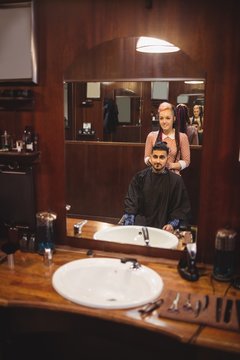 Female barber styling customer hair