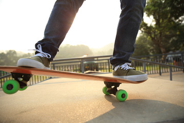 young skateboarder legs skateboarding at skatepark