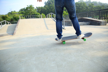 young skateboarder legs skateboarding at skatepark