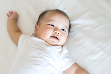 Portrait of a newborn Asian baby on the bed