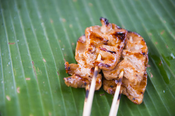 Roasting pork skewers on banana leaf