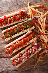 hot dogs with ketchup, mustard, onions and french fries. vertical top view 
