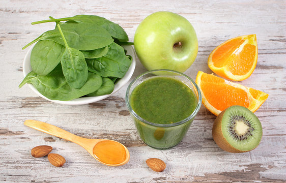 Ingredients and fresh cocktail from spinach on wooden background, healthy nutrition