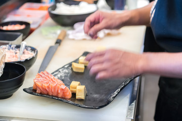 Japanese chef with a plate of sushi, making sushi - japanese food - selective focus.
