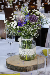 Bouquet of mixed wild flowers on rustic wedding table