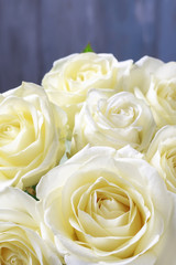 White roses on wooden background.