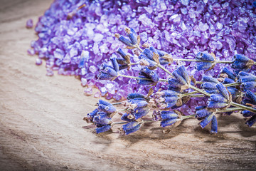 Obraz na płótnie Canvas Bunch of lavender scented sea salt on wooden board spa treatment