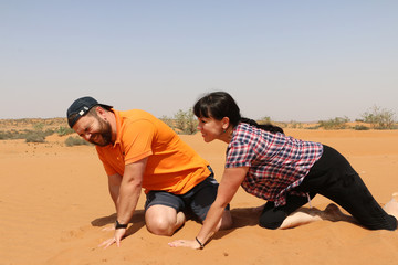 Fototapeta na wymiar Man and woman are having fun in the desert