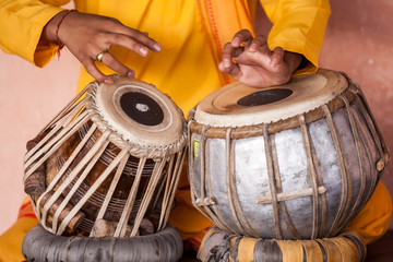 A young boy playing on traditional Indian tabla drums.  - obrazy, fototapety, plakaty